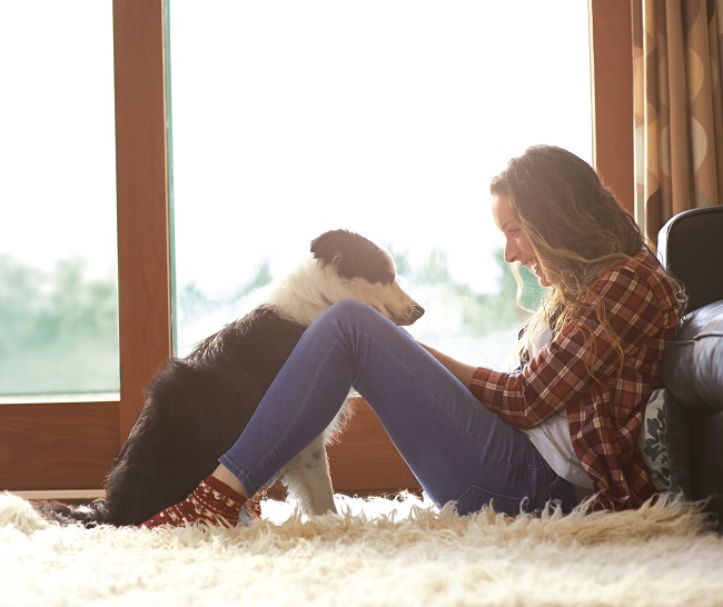 Profile of woman sitting in lounge with dog.